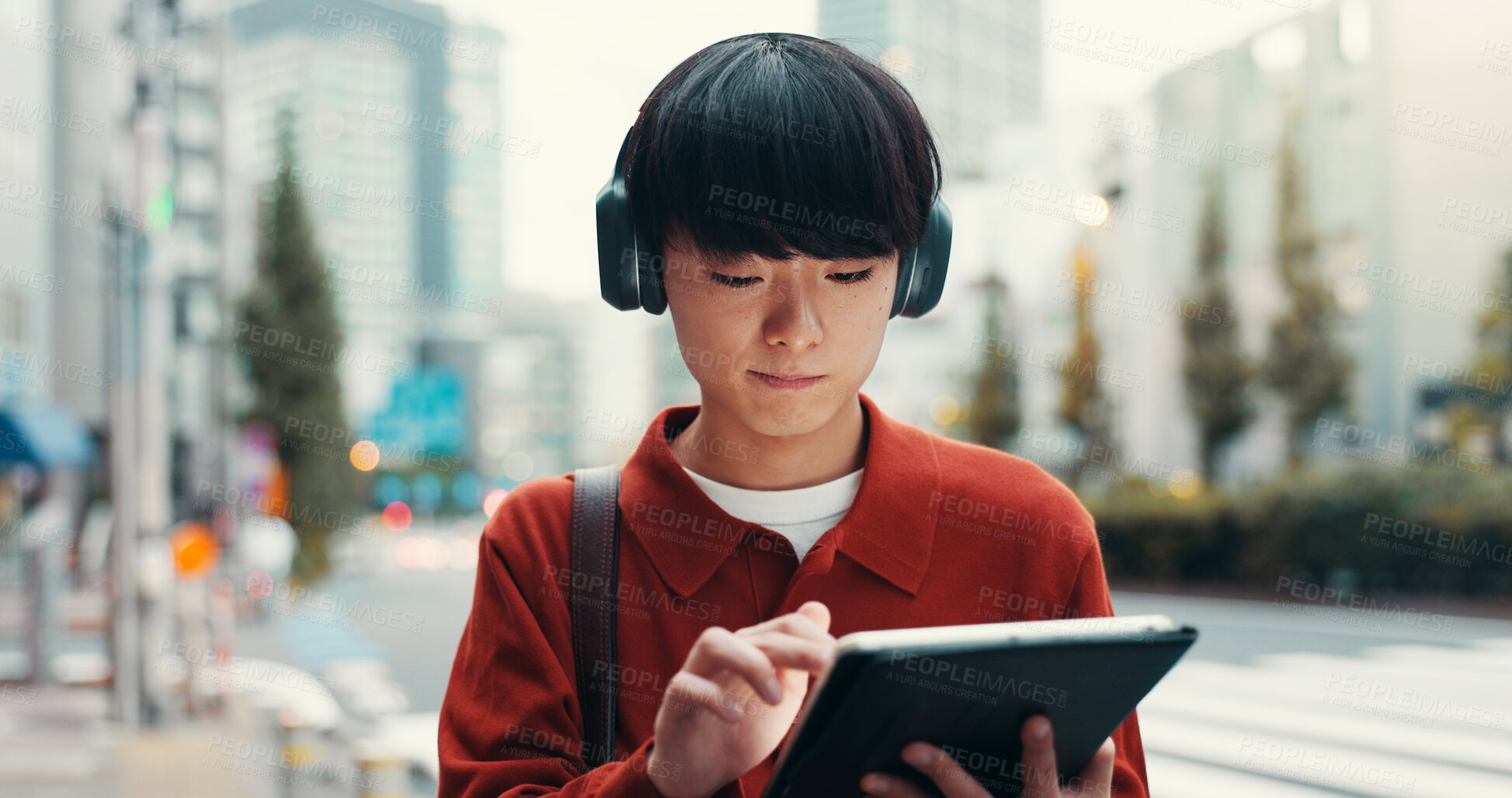 Buy stock photo Walking, headphones and man in city with tablet, morning commute or online search on sidewalk. Urban travel, street and Japanese university student on digital app for music streaming subscription