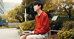 Asian man, student and thinking in park with laptop, planning or creative writing for travel blog in Japan. Japanese person, computer or idea in Tokyo for storytelling, journal editing or email reply