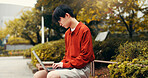 Asian man, student and laptop in park with typing, planning and creative writing for travel blog in Japan. Japanese person, computer or relax in Tokyo with social media post, journal editing or email