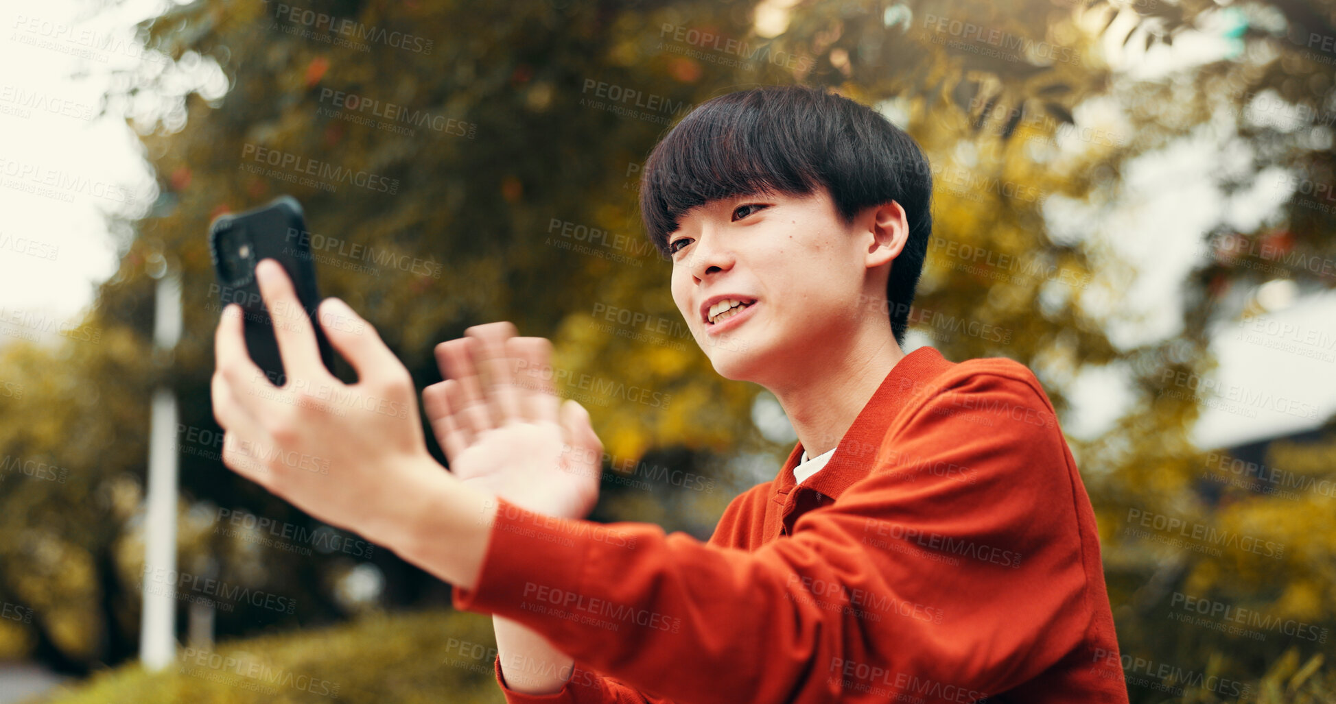 Buy stock photo Phone, video call and man in park with wave, outdoor live streaming and online communication. Smartphone, influencer or Japanese streamer in nature for content creation, networking or connectivity