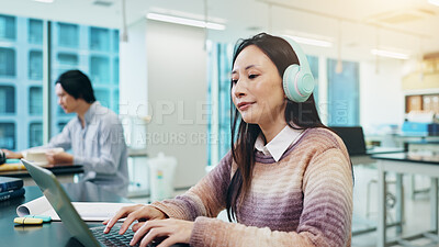 Buy stock photo Headphones, laptop and woman at university typing notes for literature assignment in class. Reading, audio tech and Japanese female student with computer studying for college exam, test or project.