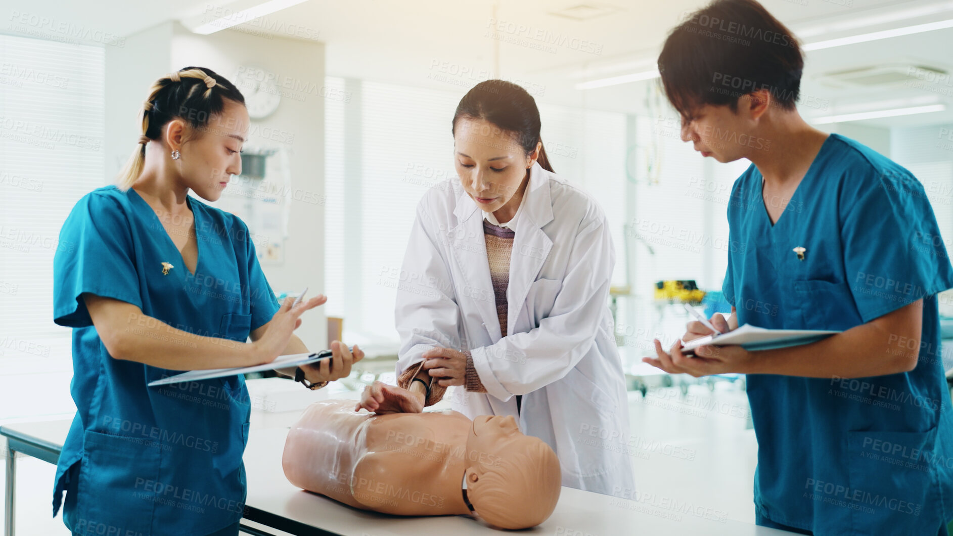 Buy stock photo Mannequin, students and cpr training in hospital for medical simulation exam, test or project. Healthcare, professor and group with rescue support demonstration on patient dummy at college in Japan.