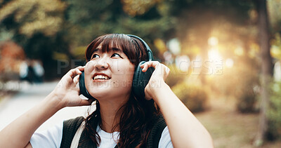 Buy stock photo Woman, headphones and student travel or thinking in city, streaming playlist and online for listening. Female person, outdoor and hearing sound on journey in Japan, university campus and planning