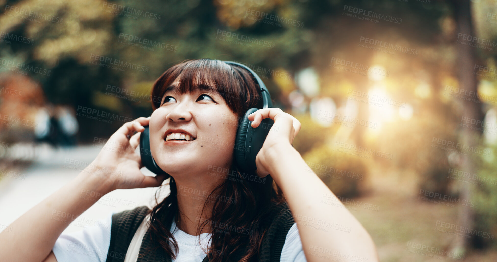 Buy stock photo Woman, headphones and student travel or thinking in city, streaming playlist and online for listening. Female person, outdoor and hearing sound on journey in Japan, university campus and planning