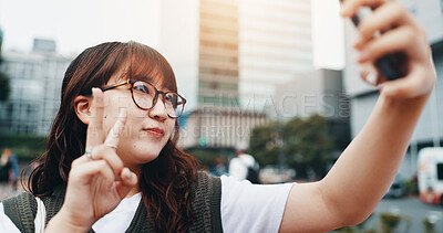 Buy stock photo Woman, selfie and travel in city with peace sign, outdoor and summer with post on web in street. Girl, person and influencer with emoji, symbol and live streaming with social media app in Japan