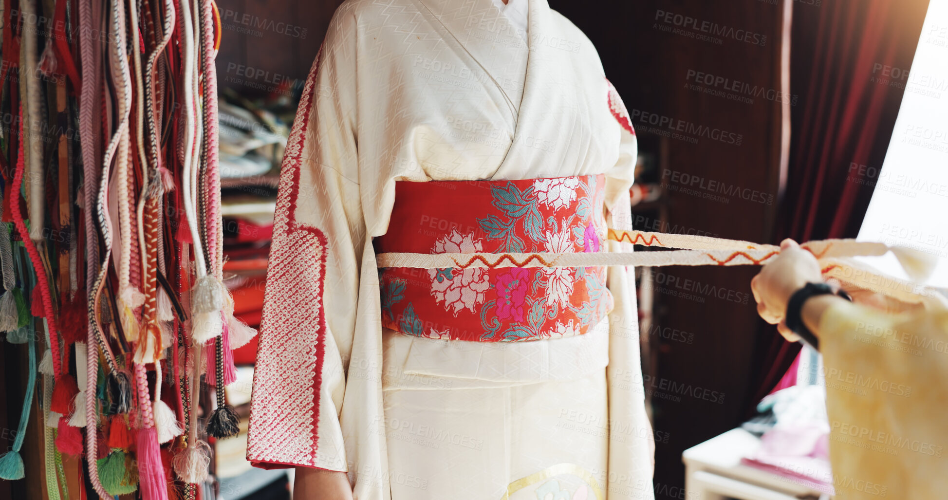 Buy stock photo Kimono, belt and help with hands of people at tailor in japan for designer, boutique and fashion. Festive ceremony, culture and traditional clothes with closeup of obi and customer for fabric shop