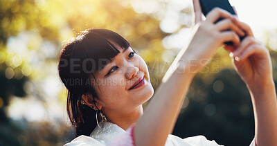 Buy stock photo Nature, selfie and woman with trees, smile and connection for social media on outdoor adventure. Influencer, streamer and Japanese girl in park on mobile app for live streaming on travel in morning