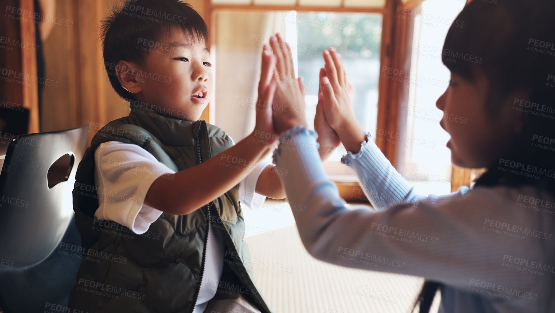 Buy stock photo Home, children and playing clapping game for bonding, cognitive development and coordination. Japanese people, kids and fun activity in living room for learning, interaction and motor skills on floor