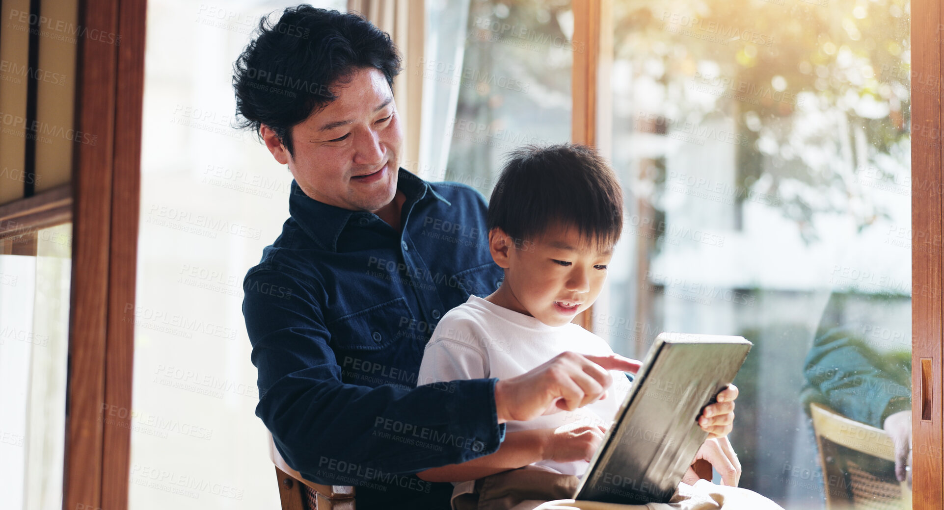 Buy stock photo Education, study or tablet with father and son on chair in home for child development or learning. Japanese family, reading or technology with single parent man and boy in apartment for search