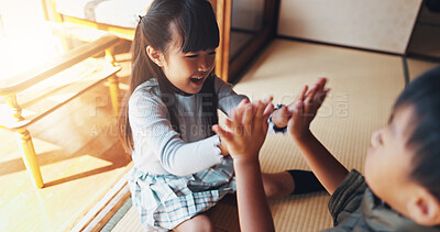 Buy stock photo Home, kids and playing clapping game for bonding, cognitive development and coordination. Japanese people, siblings and fun activity in living room for dexterity, interaction or motor skills on floor