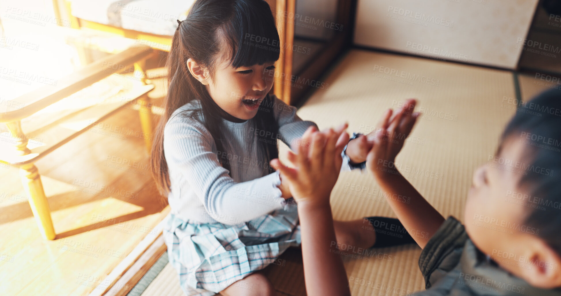 Buy stock photo Home, kids and playing clapping game for bonding, cognitive development and coordination. Japanese people, siblings and fun activity in living room for dexterity, interaction or motor skills on floor