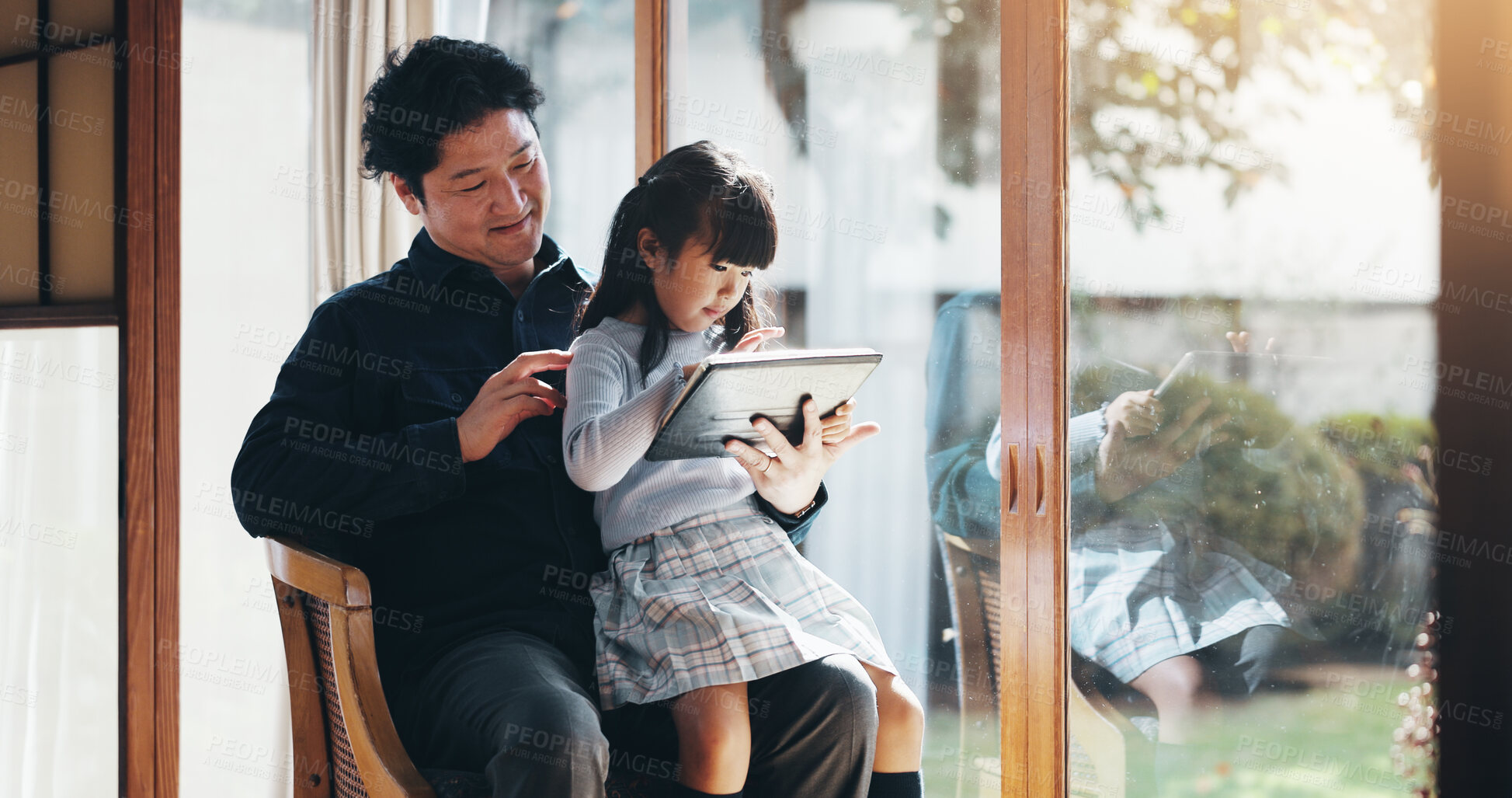 Buy stock photo Education, study or tablet with father and daughter on chair in home for child development or learning. Japanese family, reading or tech with single parent man and girl in apartment for research