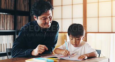 Buy stock photo Asian father, child and learning with book for education, homeschooling or youth development at home. Dad, boy or kid with homework, drawing or sketching for color, creativity or childhood in Japan