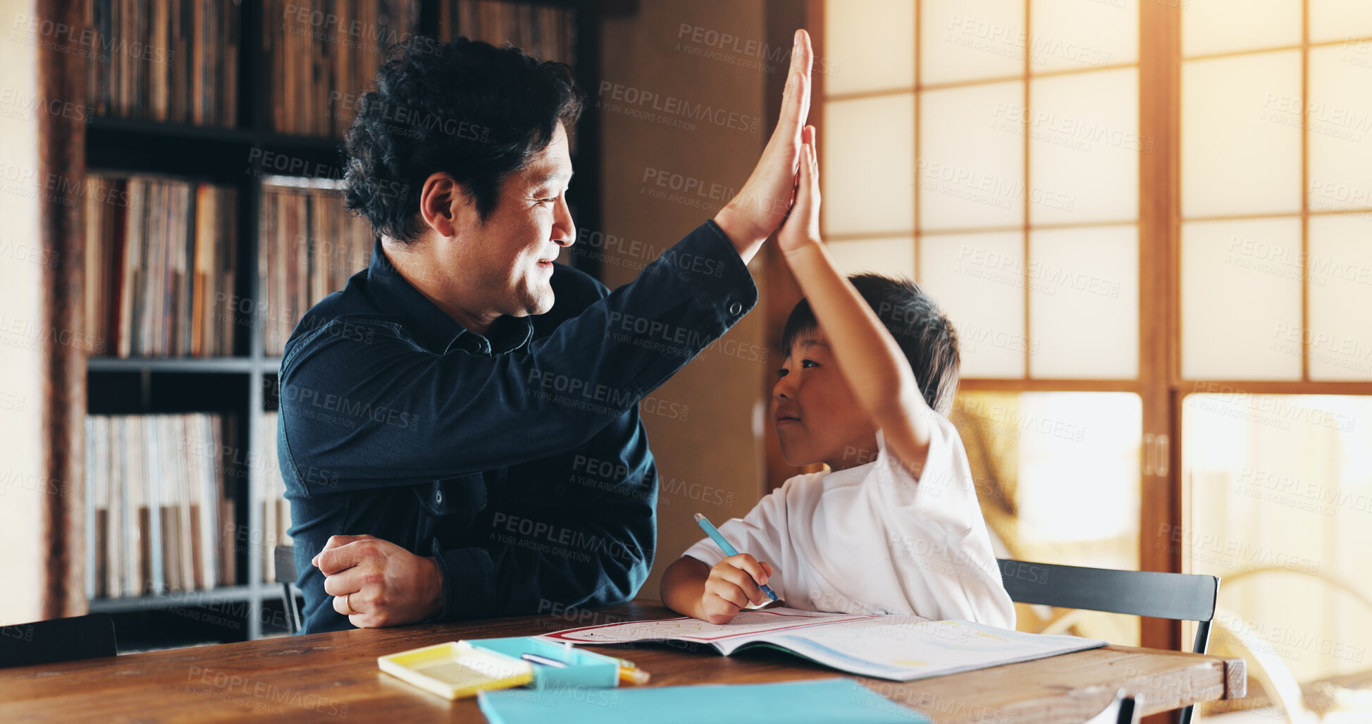 Buy stock photo Asian father, child and learning with high five for education, homeschooling or youth development at home. Dad, boy or kid with homework, winning or teamwork for creativity or childhood in Japan