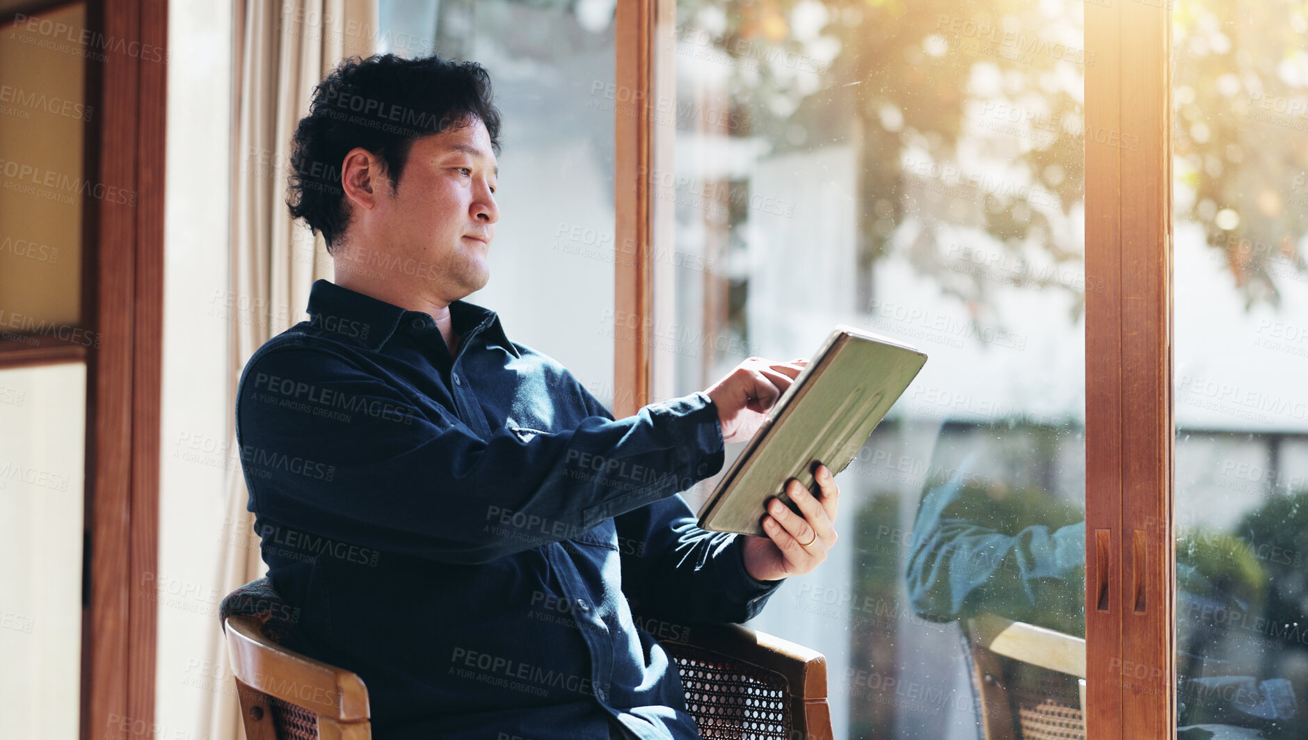 Buy stock photo Japanese, man and home with tablet for connection, search online and reading ebook with technology. House, male person and digital by flare for blog, information or news story of economy in apartment