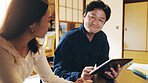 Happy, couple and tablet in home with finance planning, smile and investment of Japanese people. Web, online and bills discussion with laptop, digital and internet research for budget and savings 