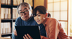 Love, retirement and tablet with senior couple in home together for browsing or social media. App, internet or technology with old Japanese man and woman in apartment for online travel booking