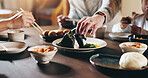 Japanese, family and hands in home with sushi, people and noodles for diet and rice. Food, help and dinner table with dumpling, care and seaweed roll with chopsticks and meal for health and nutrition