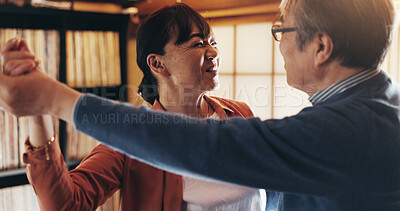 Buy stock photo Dance, retirement and smile with senior couple in home together for bonding, love or romance. Holding hands, music or relationship with happy old Japanese people in apartment to relax for wellness