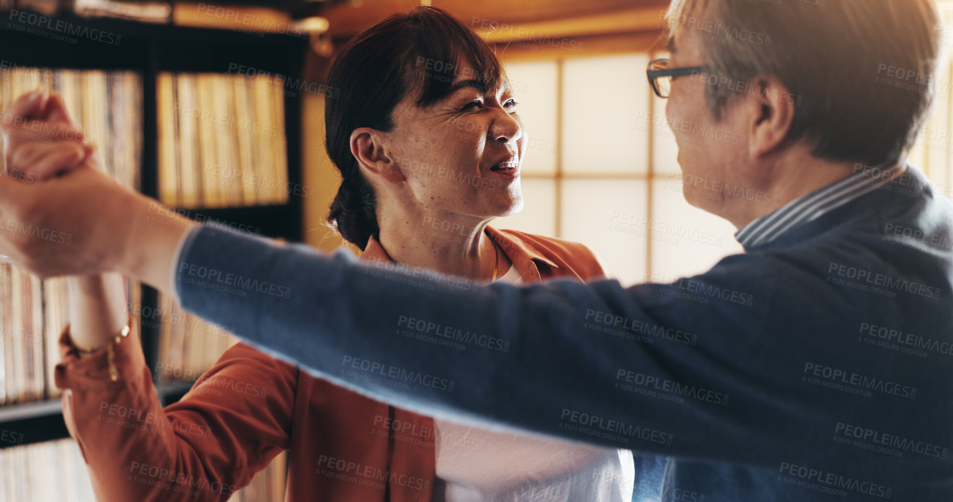 Buy stock photo Dance, retirement and smile with senior couple in home together for bonding, love or romance. Holding hands, music or relationship with happy old Japanese people in apartment to relax for wellness