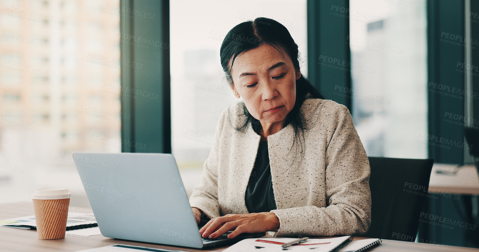 Buy stock photo Mature, business woman and Japanese with laptop, reading and notebook for review, audit or company. Female person, tech and career as accountant in finance agency for report, investment and portfolio