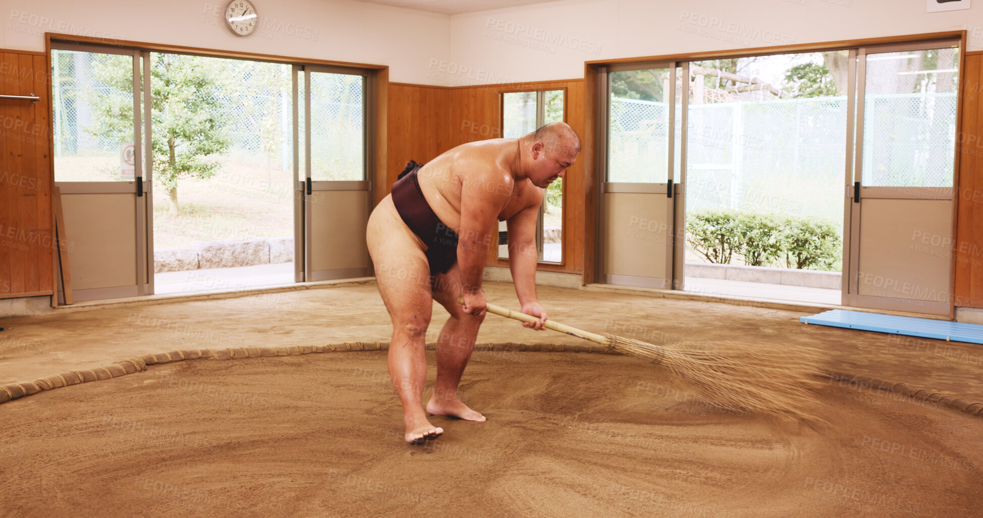 Buy stock photo Broom, dohyo and sand with Sumo wrestler sweeping arena in mawashi, getting ready for competition. Cleaning, preparation and start with Japanese person for culture, heritage or martial arts tradition