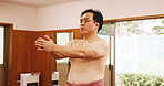 Man, ring and wrestler in Japan for sumo, fitness and exercise with preparation, skill and technique. Japanese athlete, fighter and sports in dohyo for training, workout and wrestling with warm up