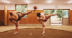 Japanese wrestlers, sumo and stretching for sport and shiko ritual in dohyo ring. Tradition, wrestling and men exercise for culture, martial arts or spiritual preparation with foot stomp for warm up