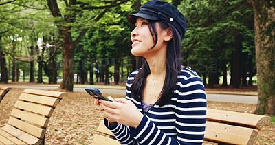 Buy stock photo Bench, phone and thinking with woman in nature for adventure, sightseeing or travel to explore Japan. App, social media and vision with smile of happy tourist person outdoor in park for vacation