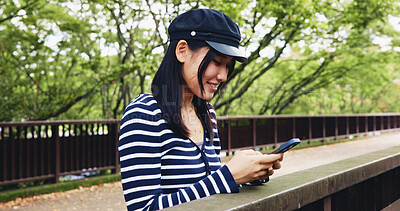 Buy stock photo Bridge, phone and smile with woman in park for adventure, sightseeing or travel to explore Japan. App, relax and social media with happy tourist person outdoor in nature of Tokyo for vacation