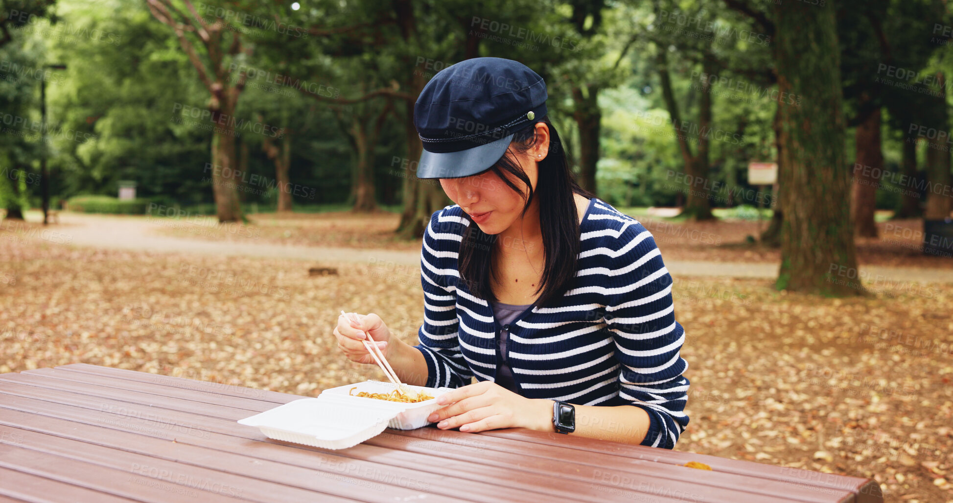 Buy stock photo Park, woman and eating with takeaway of food as lunch on break, relax and enjoy in Japan. Outdoor, female person and chopstick with noodles as meal, snack and cuisine at forest with memories and rest