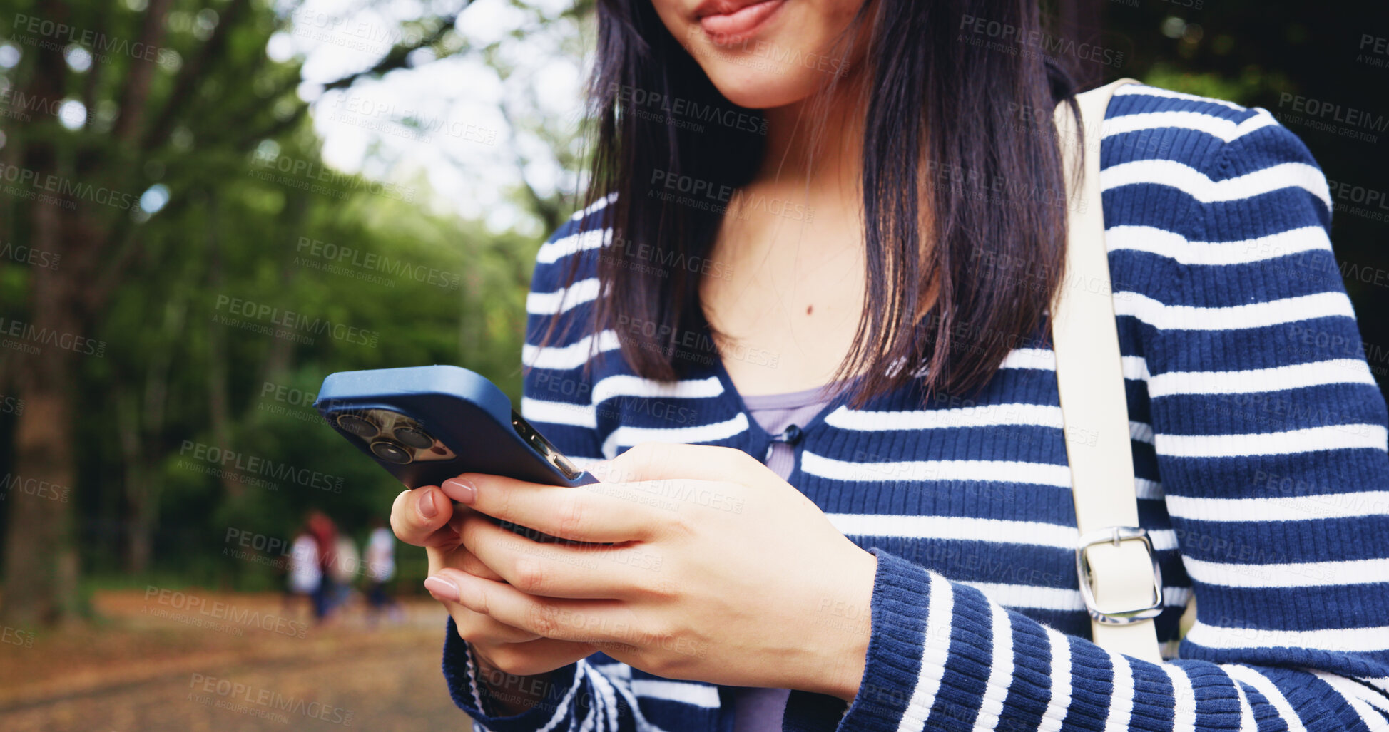 Buy stock photo Hands, woman and typing with phone at park for communication, travel location and social media post. Female person, mobile and morning commute, reading blog and tourist destination of nature in Japan