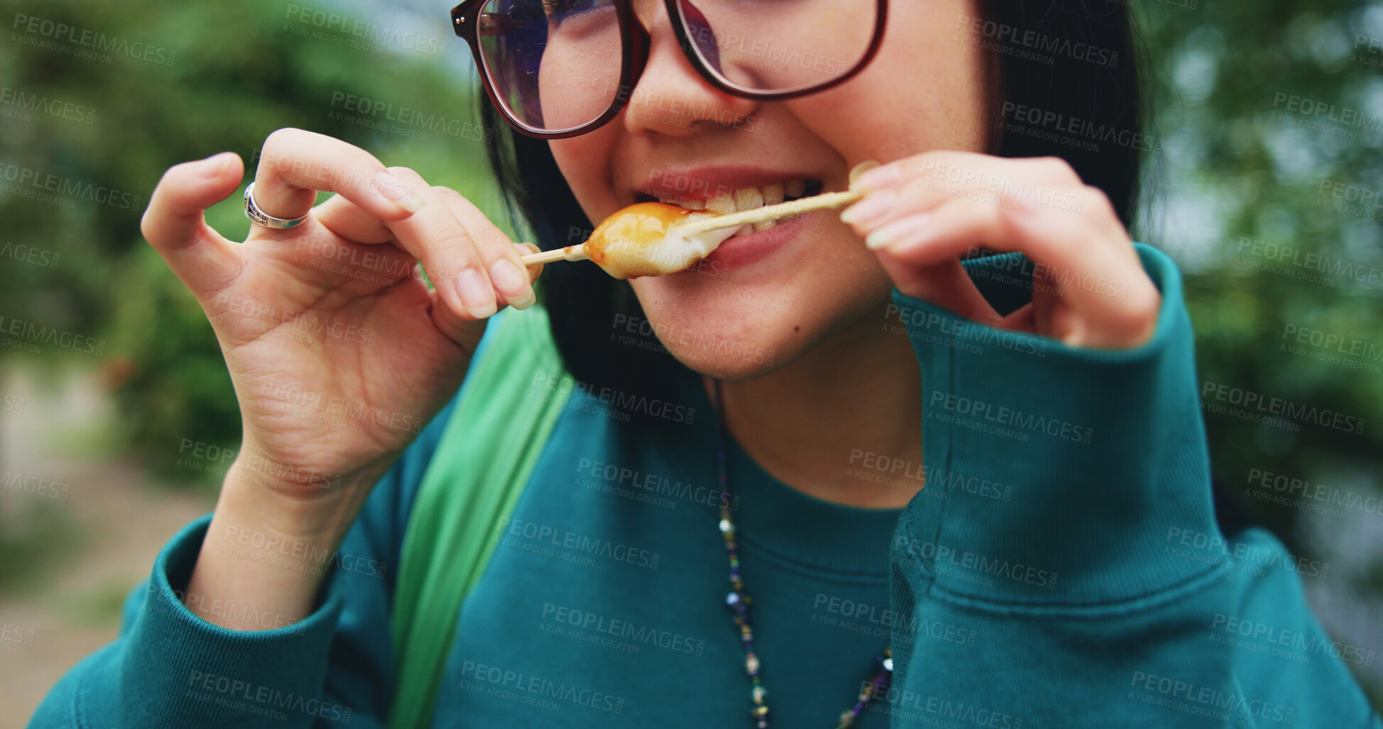 Buy stock photo Hands, eating and woman with snack in city on vacation, adventure or weekend trip for journey. Travel, fun and hungry Japanese female person enjoying dango for dessert in urban town on holiday.