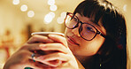 Woman, coffee and thinking in cafe with glasses, relax or study break at night with bokeh. Japanese student, matcha drink or daydream in Tokyo restaurant with peace, green tea or calm with reflection