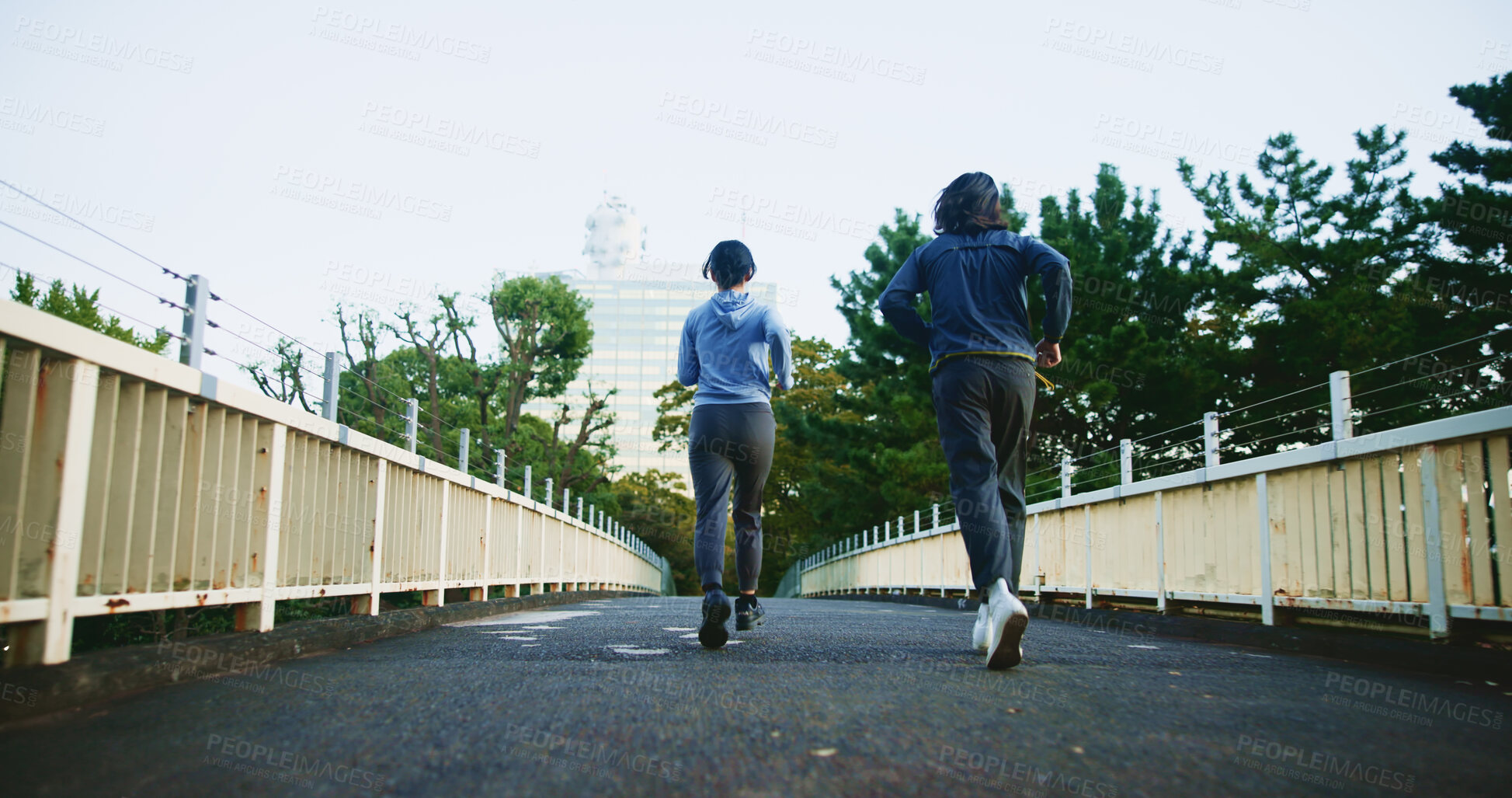 Buy stock photo Outdoor, couple of friends and running for fitness at bridge for self care, wellness and health in Japan. People, back and jogging in Tokyo for exercise, cardio. and workout with support and love