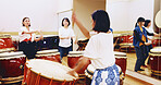 Japanese drums, teacher or people in class for music on instrument for stage creativity, hobby or song. Taiko, women or coaching drummers in band to play in rehearsal for culture, rhythm and beat