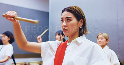 Buy stock photo Japanese, drums and woman in practice for music on instrument for performance, creativity or class. Taiko, people or female drummers learning in band to play in rehearsal for culture, rhythm or beat