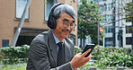 Business, music and phone with mature man outdoor in city for break from job or work. Communication, headphones and smile with corporate Japanese employee outdoor in urban town for text message