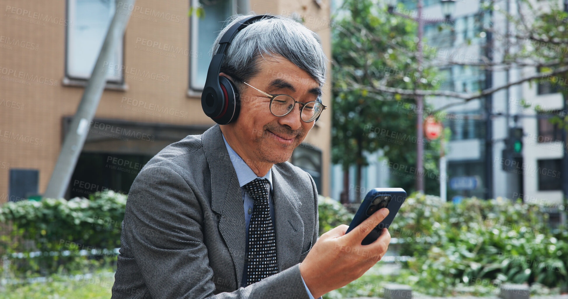 Buy stock photo Business, music and phone with mature man outdoor in city for break from job or work. Communication, headphones and smile with corporate Japanese employee outdoor in urban town for text message