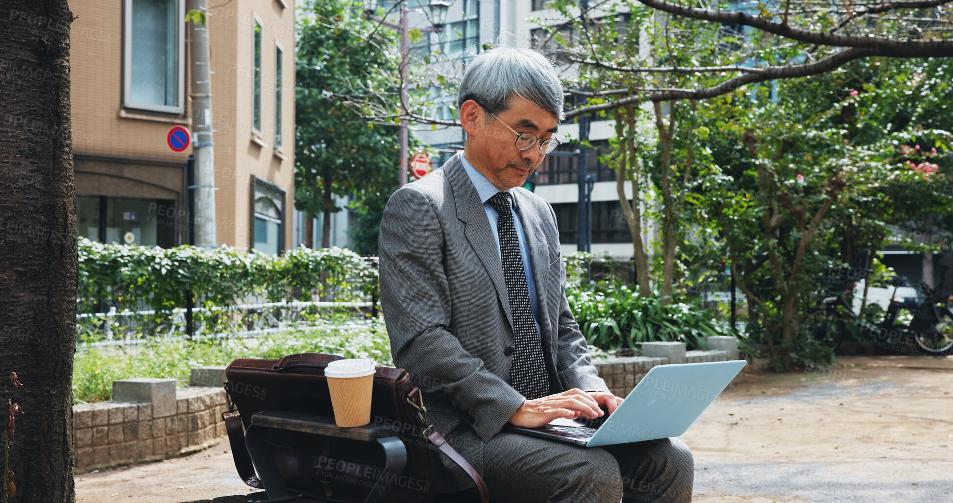 Buy stock photo Outdoor, businessman and research on laptop in city for email marketing and communication as lawyer in Japan. Mature person, employee and serious in downtown Tokyo for policy or legal document update