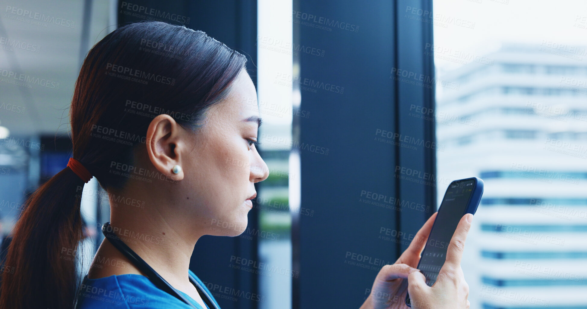 Buy stock photo Medical student, mobile phone and typing in hospital for communication or networking in Japan. Female person, technology and texting for post, update or chat with serious, concentration or confidence
