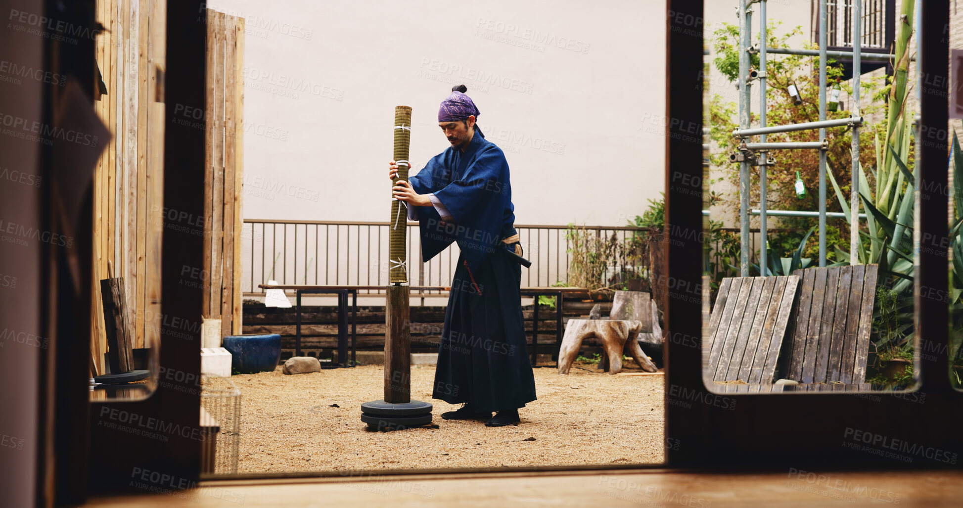 Buy stock photo Japanese, man and martial arts with bamboo stand for samurai training, practice or tradition. Male person, kenjitsu trainer or culture with demonstration for shinkendo preparation or tameshigiri dojo