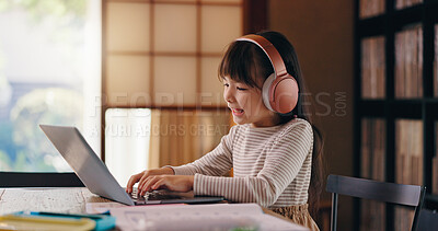 Buy stock photo Elearning, studying and child with laptop, headphones and education for girl, listening or typing. Home, happy and online and practice for exam, audio and podcast for knowledge, smile or kid in Japan