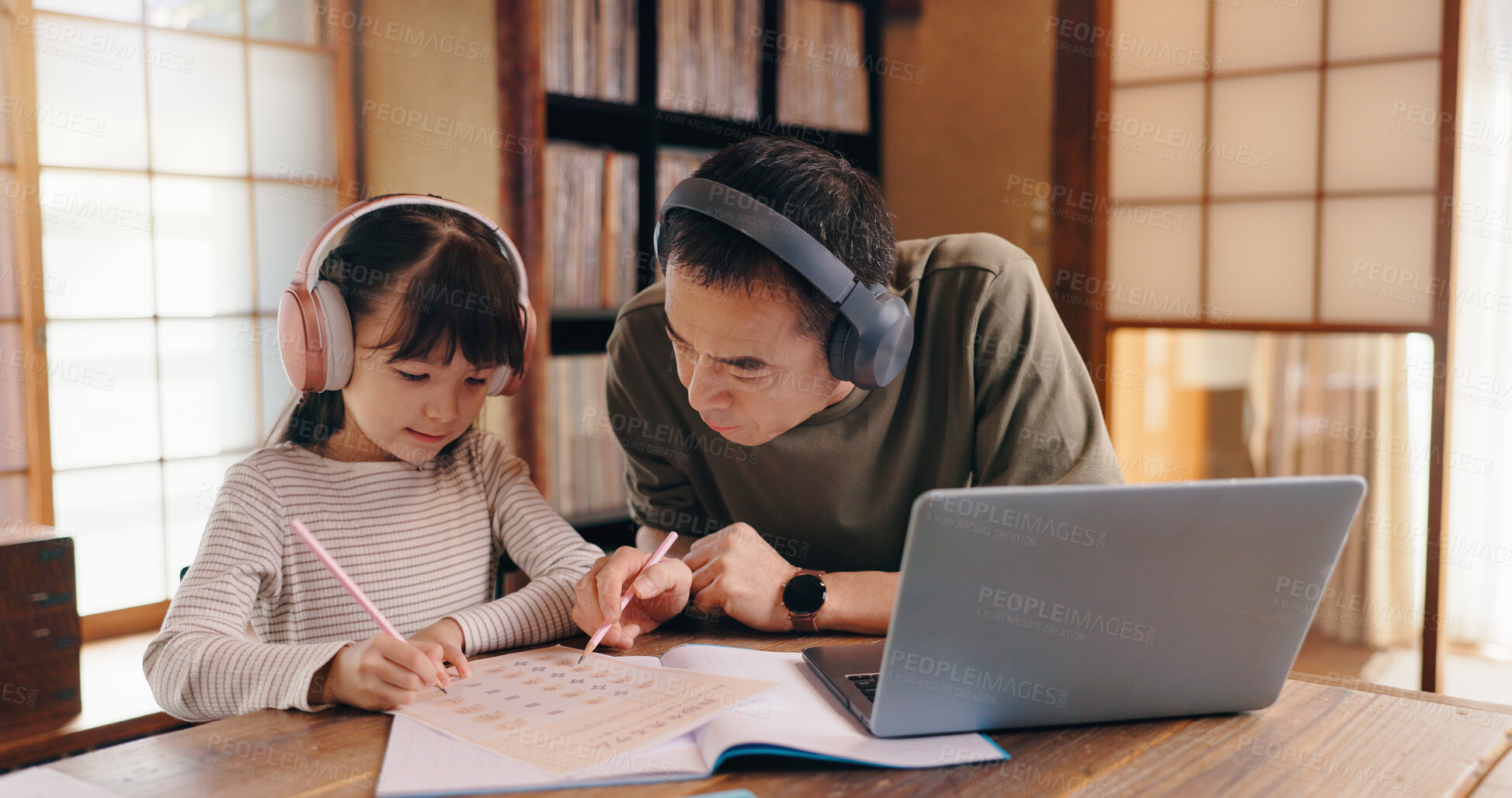 Buy stock photo Asian father, daughter and headphones with laptop for online learning, language tutoring or teaching at home. Japan, dad or child writing with book or computer for lesson or homeschooling at house