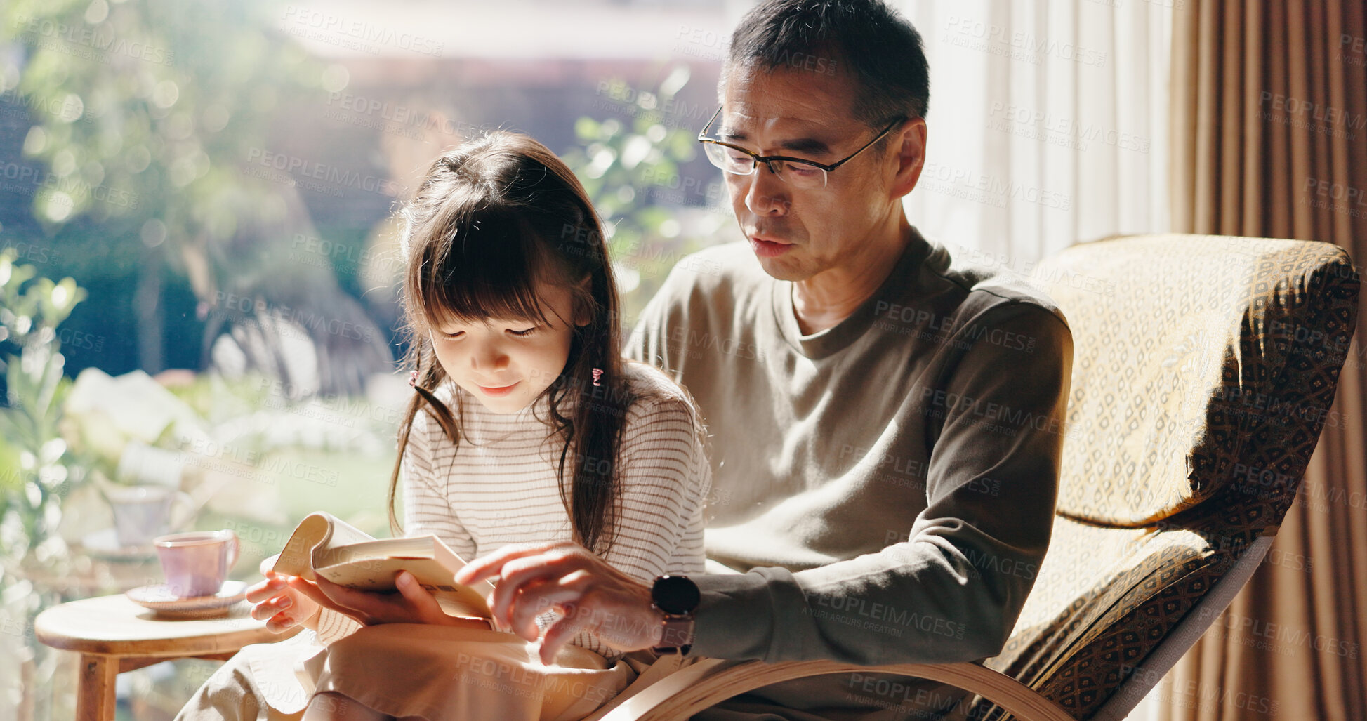 Buy stock photo Father, girl and reading with book in living room with learning, language and education in family house. People, dad and child with literature, listening and storytelling for development in Japan