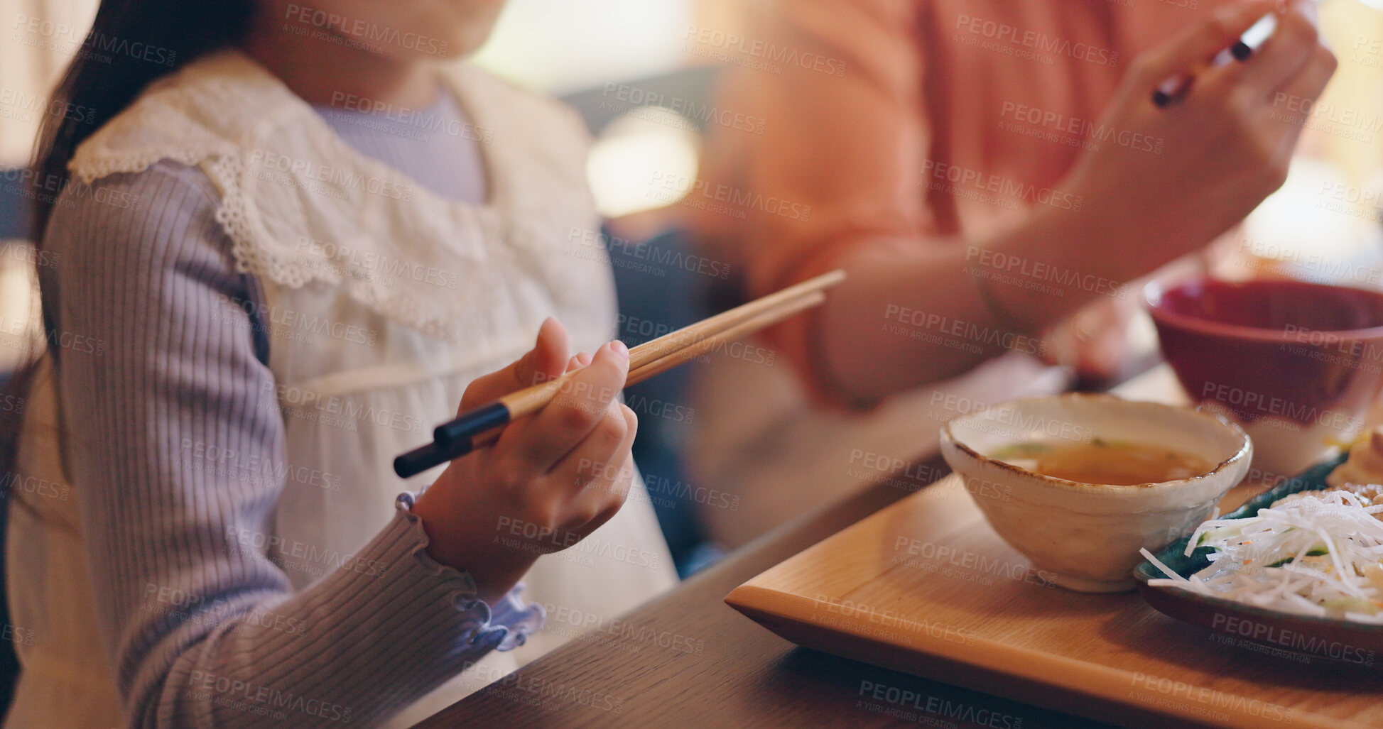 Buy stock photo Home, child and hands with chopsticks for food, nutrition and wellness with Japanese culture for lunch. Closeup, family and girl with healthy meal for eating, supper and bonding with parent in house