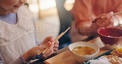 Buy stock photo Closeup, child and hands with chopsticks for food, nutrition and wellness with Japanese culture for lunch. Home, family and girl with healthy meal for eating, supper and bonding with parent in house