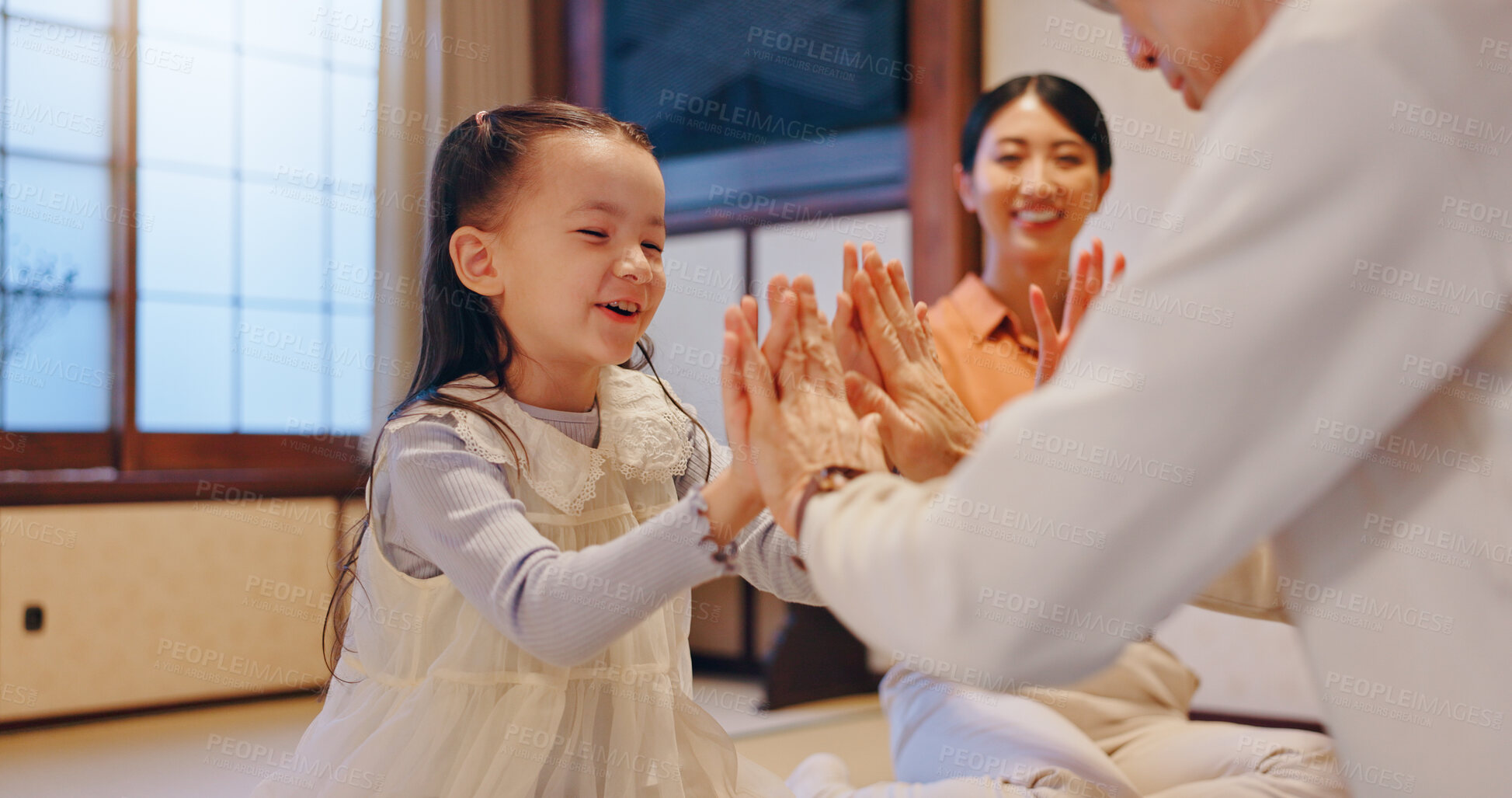 Buy stock photo Playing, child and clapping with family, home and fun with parents, growth and development for girl. House, Japanese people and games with kid, love and bonding with youth, smile and care in Japan