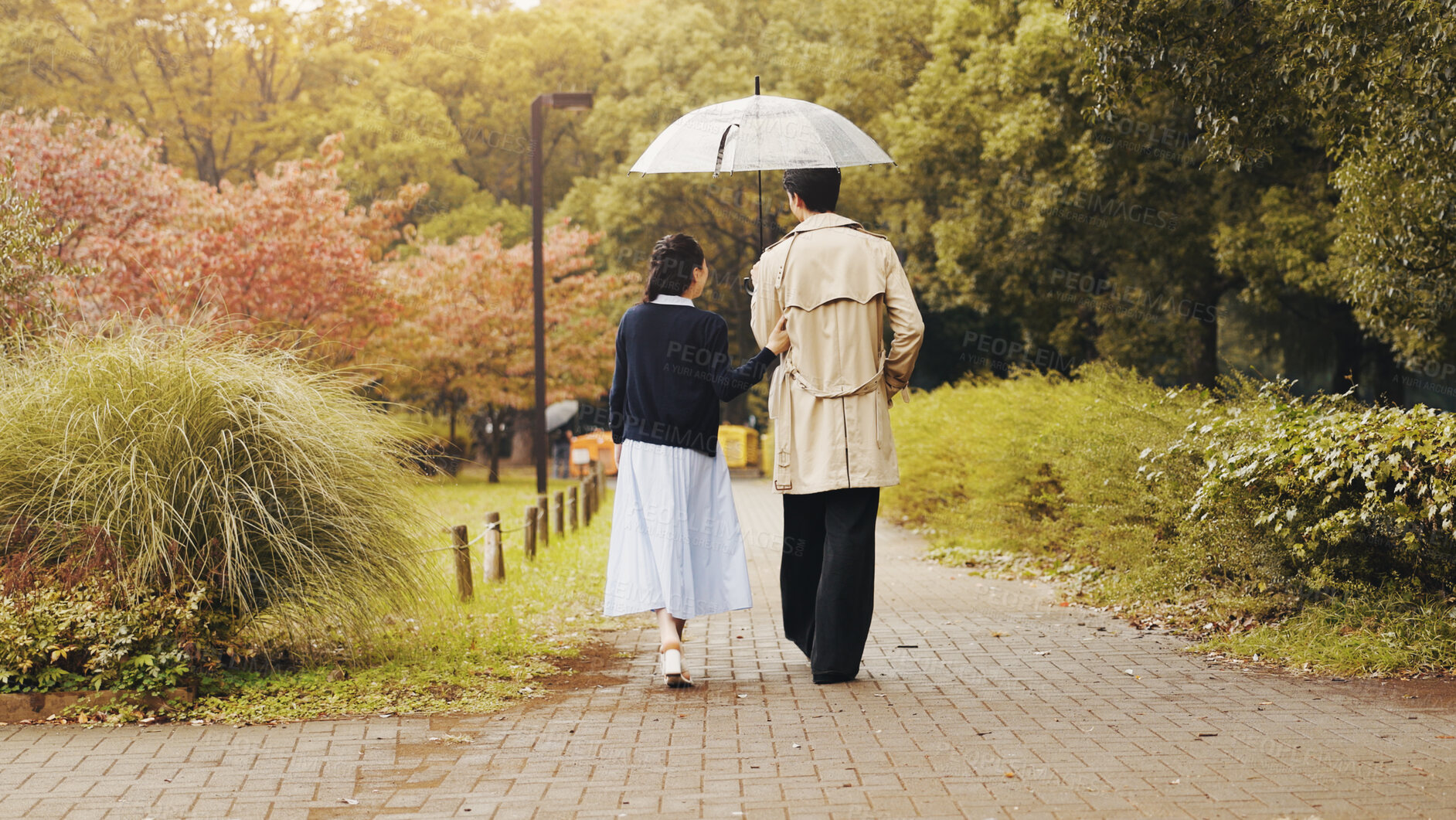 Buy stock photo Date, back and umbrella with couple walking in park for romance, bonding and relationship. Support, care and calm with man and woman in Japan nature for holiday, commitment and peace together