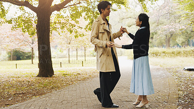 Buy stock photo Love, dance and holding hands with Japanese couple in park for romance, bonding and relationship. Support, care and happiness with man and woman in Japan nature for date, commitment and peace